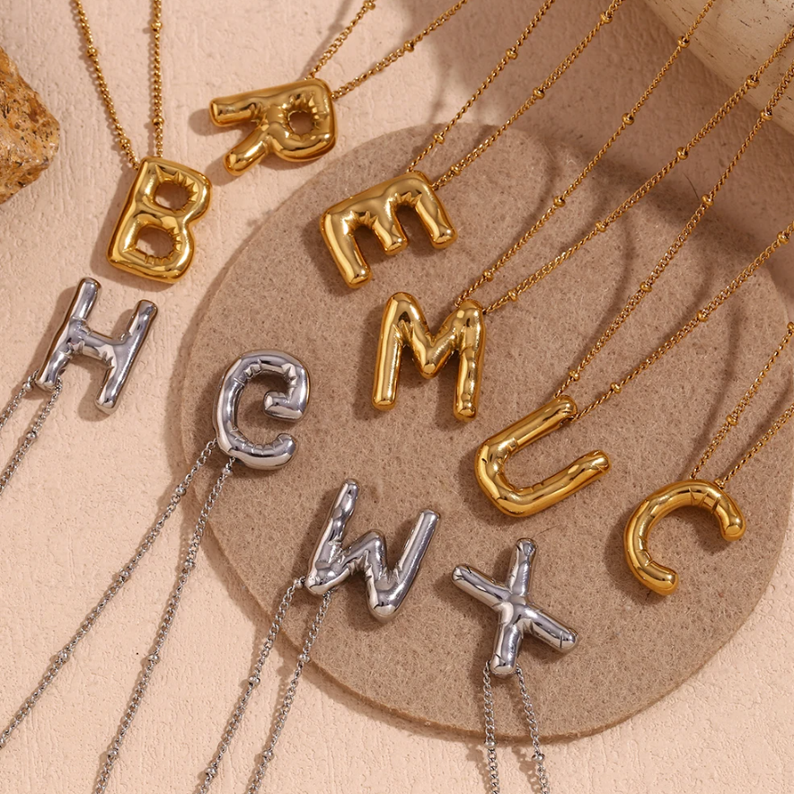 bubble initial necklace flat lay